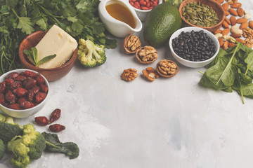 Healthy food nutrition dieting concept. Assortment of high vitamin E sources. Oil, nuts, avocado, butter, healthy fats, rose hips, parsley, seeds, spinach. White backgdound, copy space