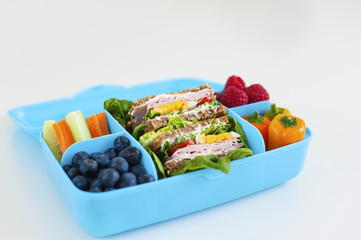 Blue lunch box with healthy food. Side view