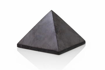 Healing shungite pyramid isolated on white background with shadow reflection. Polished shungite...