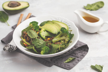 Lentil curry salad with broccoli and avocado on white background. Healthy vegan food concept.