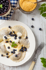 Delicious dumplings with fresh blueberries served with whipped cream and sugar or sauce.
