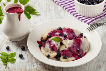 Delicious dumplings with fresh blueberries served with whipped cream and sugar or sauce.