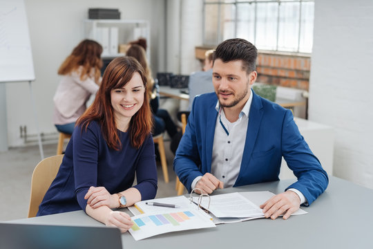 Man discussing project with woman in office