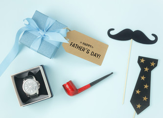 Table top view Happy Fathers day holiday background concept.Flat lay watch gift for dad with accessories objects sign of season on modern rustic blue paper at home office desk.Pastel tone design.