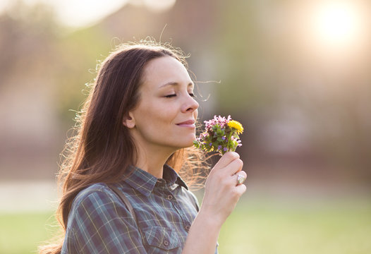 Pretty Woman Smelling Flowers