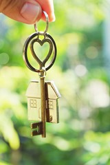 Home key with love house keyring hanging with blur garden background - 201826200