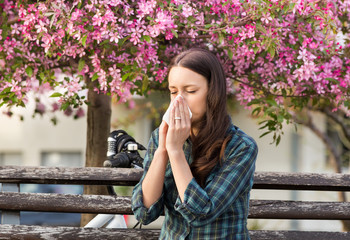 Woman sneezing because of spring pollen allergy