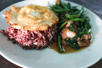 rice topped with fried egg and stir-fried vegetable