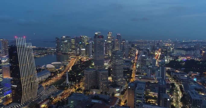 4k aerial footage of Singapore skyscrapers with city skyline during cloudy evening