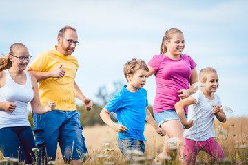 Fototapeta premium Family running for better fitness in summer jogging over a field