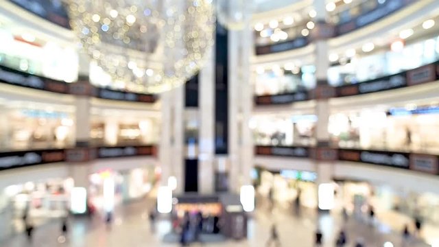 Blurred shopping mall hall. Blurry walking people and elevators in shopping mall center