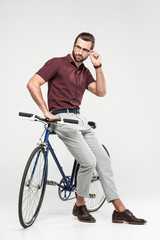 Fototapeta na wymiar elegant man posing with bike, isolated on grey