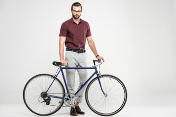 Fototapeta premium stylish man posing with bike, isolated on grey