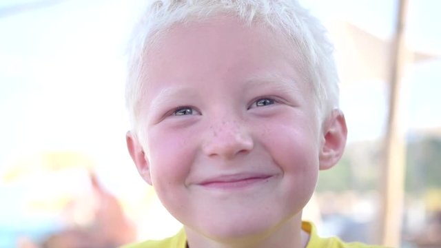 Cute young albino boy looking at camera and smiling. slow motion. 1920x1080. full hd