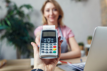 Picture of florist with calculator at table with laptop