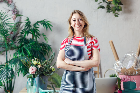 Photo of smiling woman with florist arms crossed