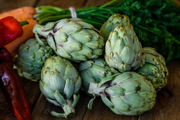 artichokes, peppers and carrots on wooden table