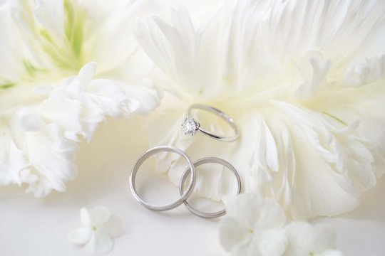 結婚指輪と婚約指輪と白い花びら