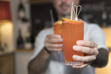 orange cocktails in hands