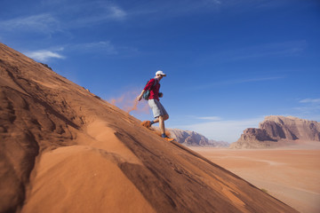Man runs down the dune in the Wadi Rum desert, Jordan