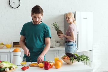 boyfriend cutting fruits for vegan meal at kitchen