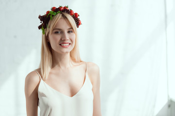 portrait of smiling woman in dress with wreath made of fresh lettuce and cherry tomatoes, vegan lifestyle concept