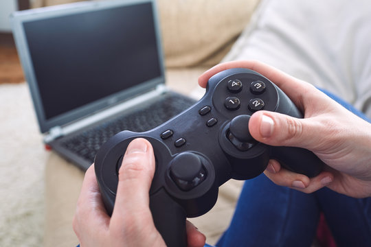 man holding a joystick controllers while playing a video games at home