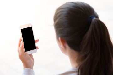 young woman looking at the smartphone, isolated on white background