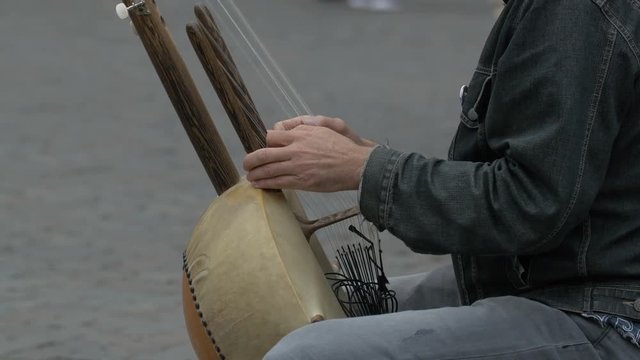Close up of hands playing a kora instrument