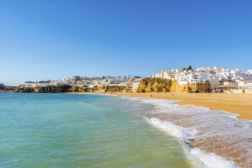 Fototapeta na wymiar Sandy beach and cliffs in white city of Albufeira, Algarve, Portugal