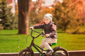 Fototapeta na wymiar Happy little boy riding a bike