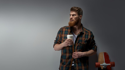 Dramatic shot of handsome young bearded man having coffee Male taking rest and drinking fresh...