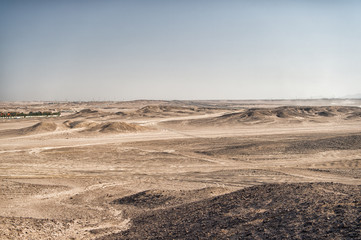 Desert landscape on clear blue sky background. Dune land with dry terrain surface. Ecology and global warming effect. Hopelessness and lifeless concept, copy space