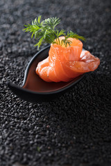 Salted salmon with dill on the background of black sesame.
