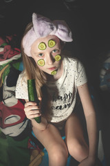 The young girl with cucumbers on her face, concept of beauty and health before the sleeping