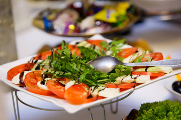 A dish of tomatoes and cheese and drizzled with balsamic sauce.