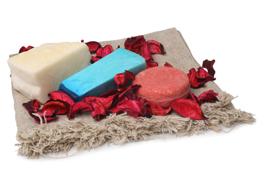 Spa composition with toilet soap with dry red petals on canvas fabric