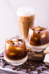 Iced coffee in glasses with milk. Black background