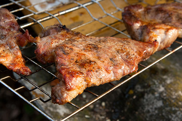 Close up view of juicy pork steak cooked on an open flame grill..