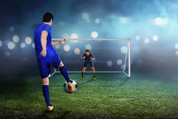 Foto op Plexiglas Professional asian soccer player man kick the ball to goal © Leo Lintang