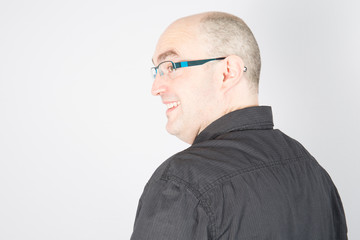 Close up studio shot of bald happy smiling confident man with glasses