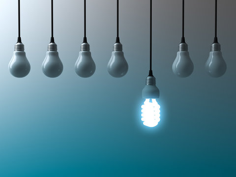 One hanging eco energy saving light bulb glowing and standing out from unlit light bulbs on dark green blue background , leadership and different creative idea concept. 3D rendering.