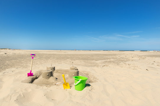 Sand castle with toys at the beach