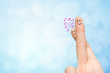 Human hand fingers with funny painted emoticons. People relationships concept