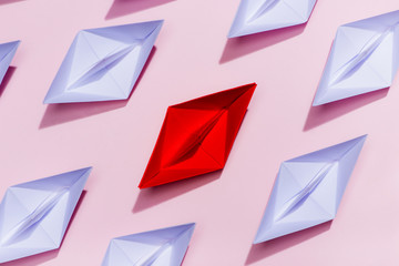 Leadership concept. Red paper ship leading among white