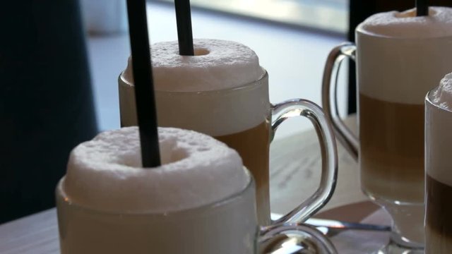 Beautiful glasses with coffee latte and big foam in the cafe on the table