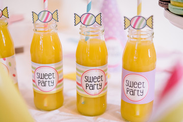 bottle with yellow orange juice at a children's sweet party