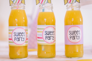bottle with yellow orange juice at a children's sweet party