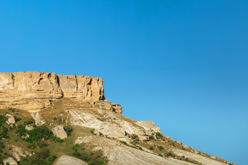 Fototapeta na wymiar View of White rock or Aq Qaya on a Sunny summer day. Crimea. White limestone with a vertical cliff