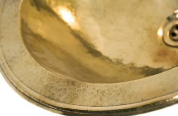 Detail of yellow brass round sink. Golden sink in retro style. Antique sink for home. Macro shooting.